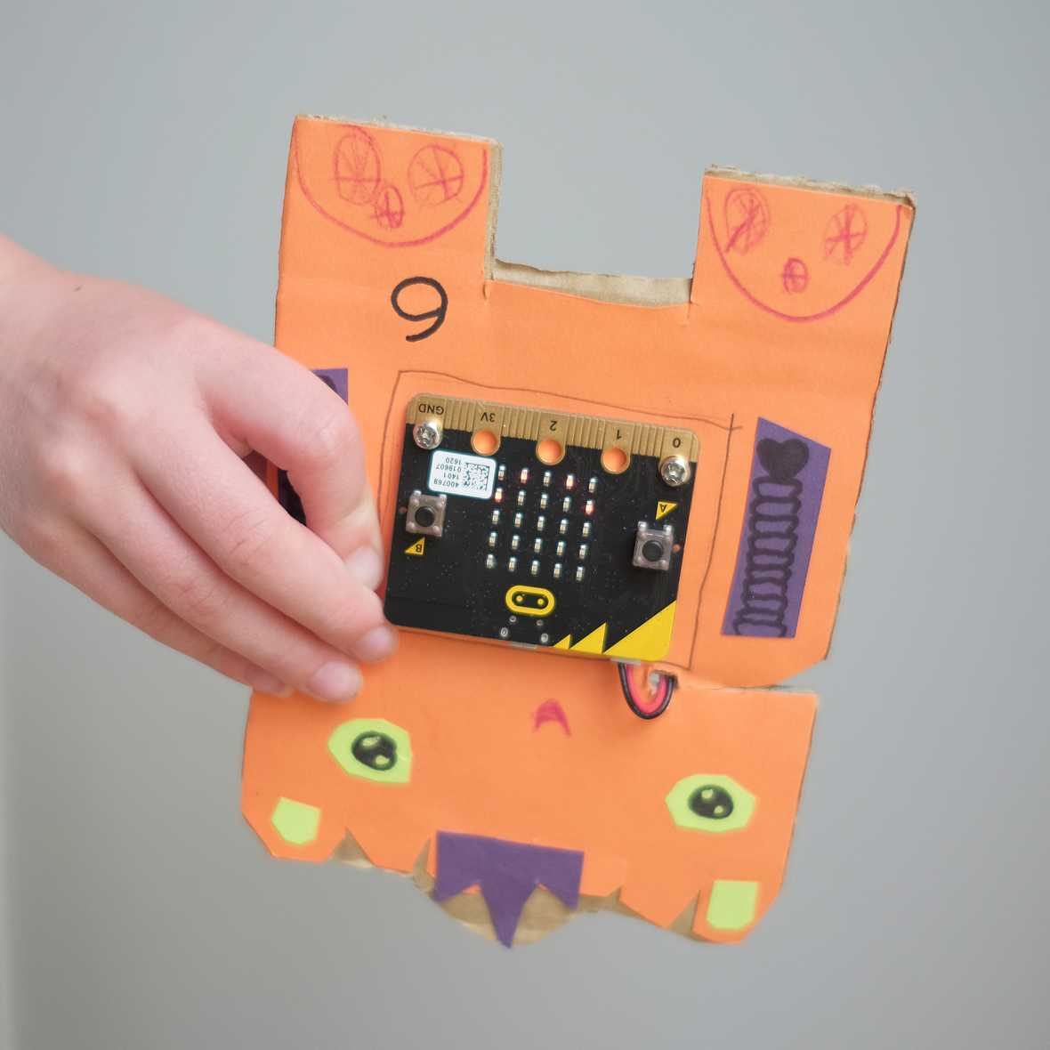 A micro:bit robot being held upside down